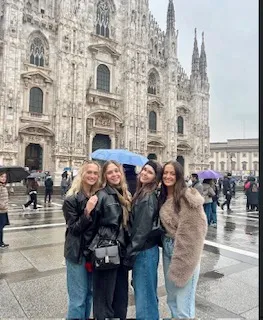 Group of four students on a rainy day in Milan, Italy