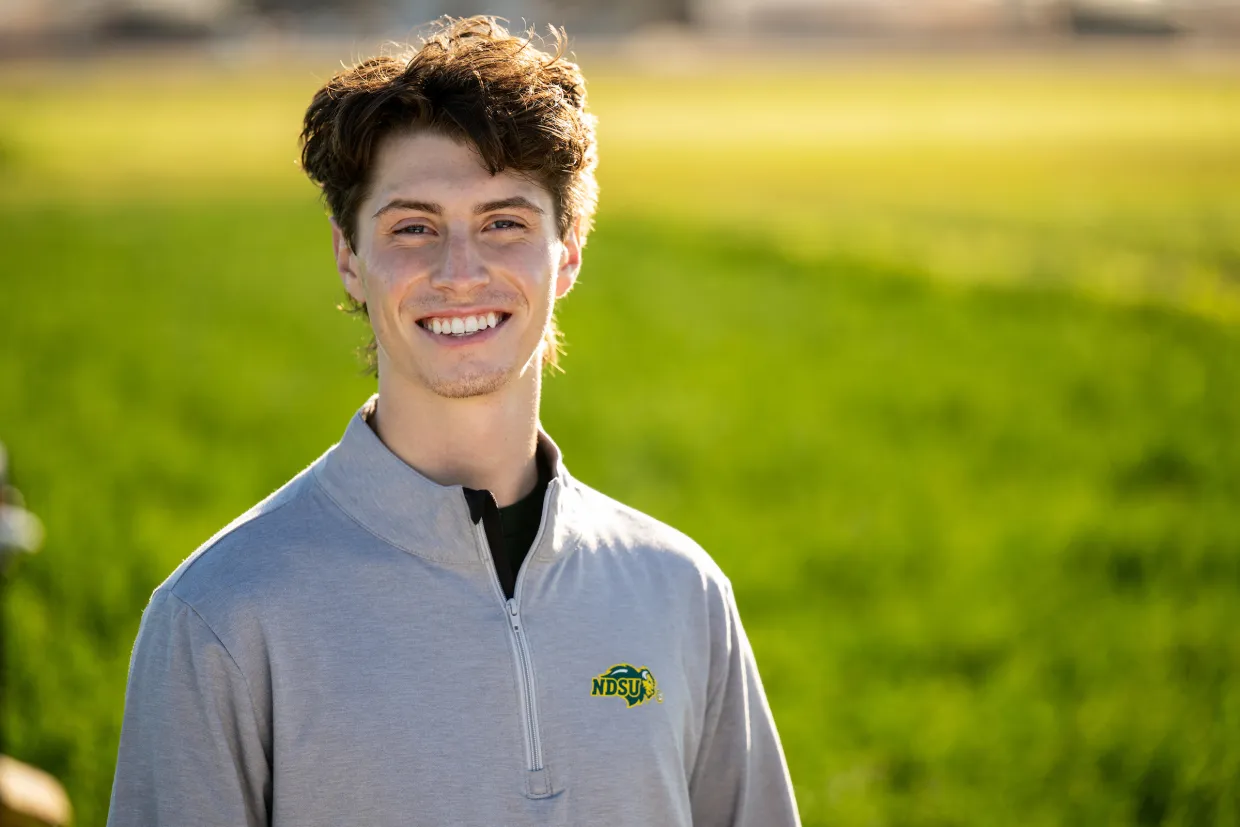 Isaac Mauch, an ag tech major standing in a field.