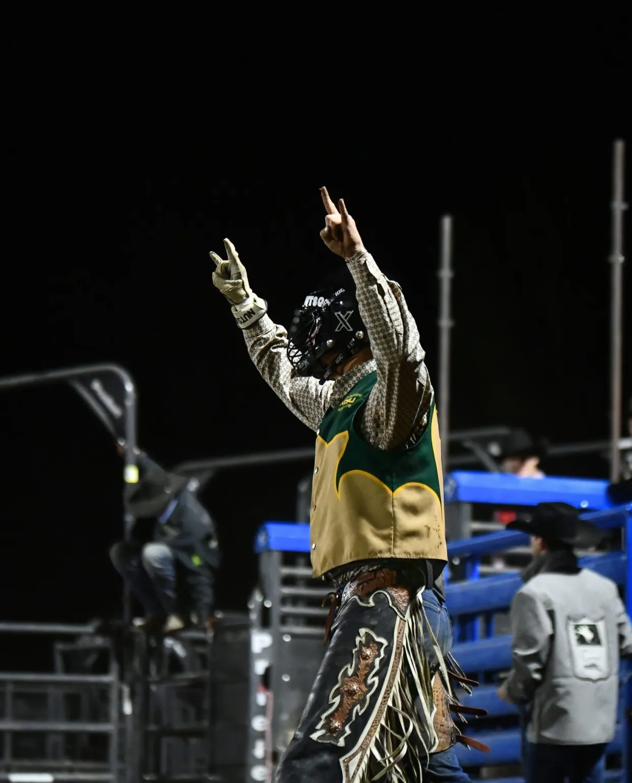 NDSU Alumni Lathan Demontigny giving horns up after bull riding event at rodeo