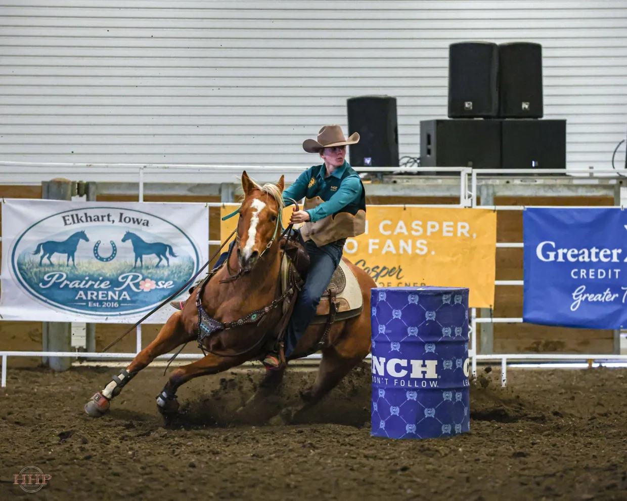 NDSU Alumni Megan Larson Riding Horse During Barrel Racing at Rodeo turning around barrel