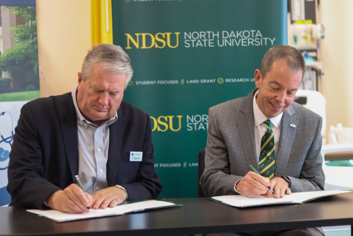 DSU President Molander and NDSU President Stewart sign agreement.