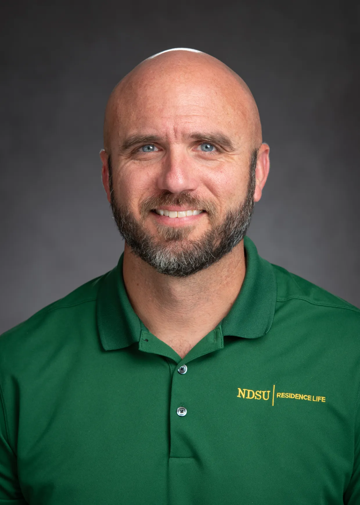 jason medders headshot, wearing green ndsu residence life polo