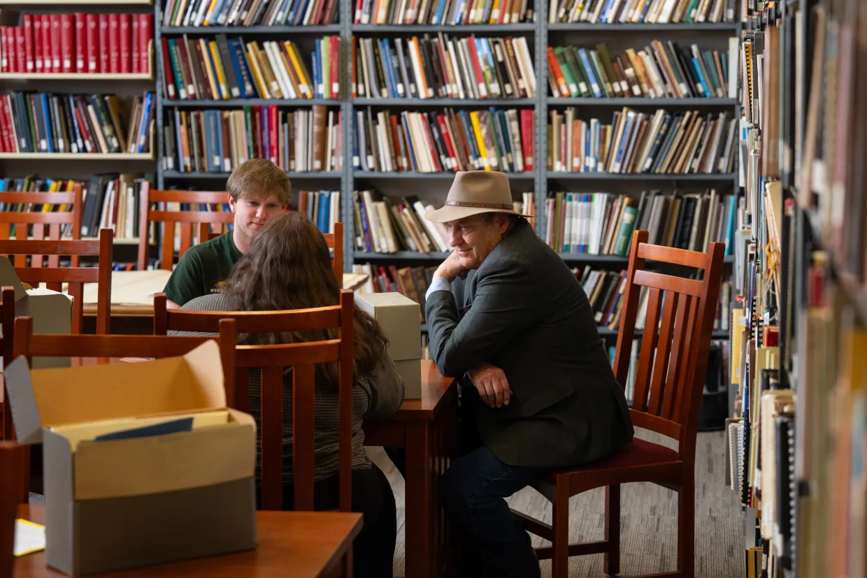 a professor and students sit around a table