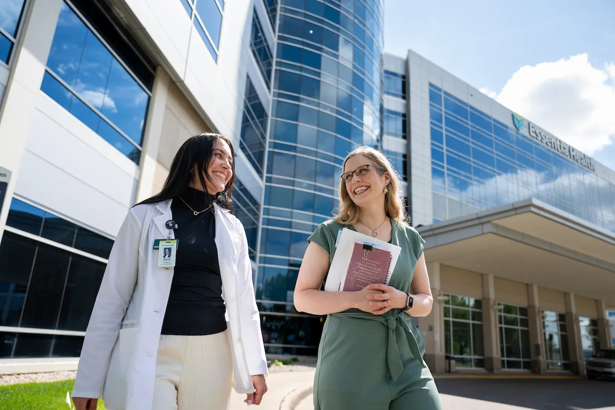 Exterior shot of Essentia Health in Fargo with Dana and Maari walking and talking