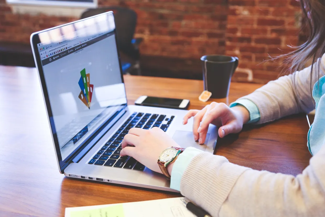 person on laptop typing with design image on screen