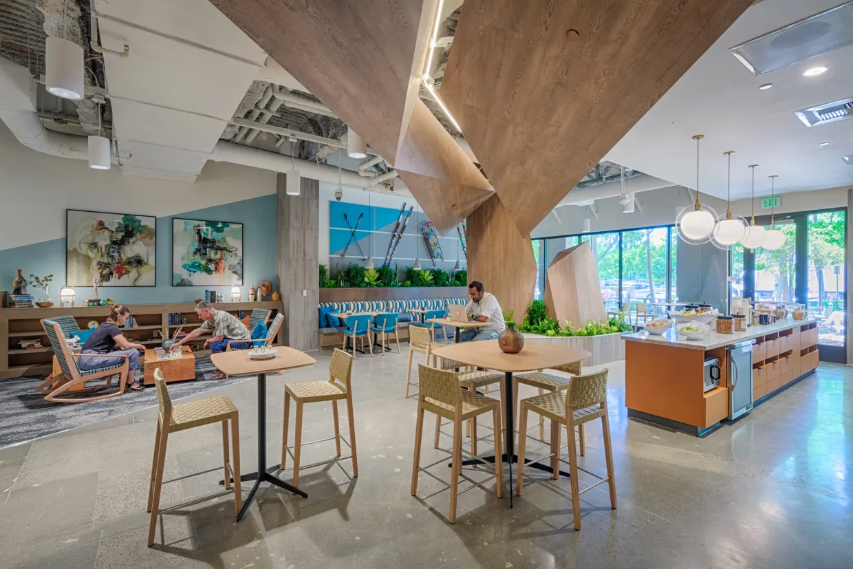 Large room with tables, chairs, sitting area and island.