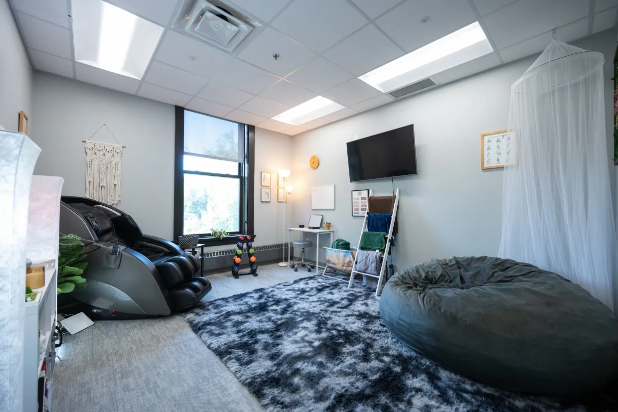 Relaxation Room in Counseling Center with massage chair, mindful activities, rug and bean bag chair.