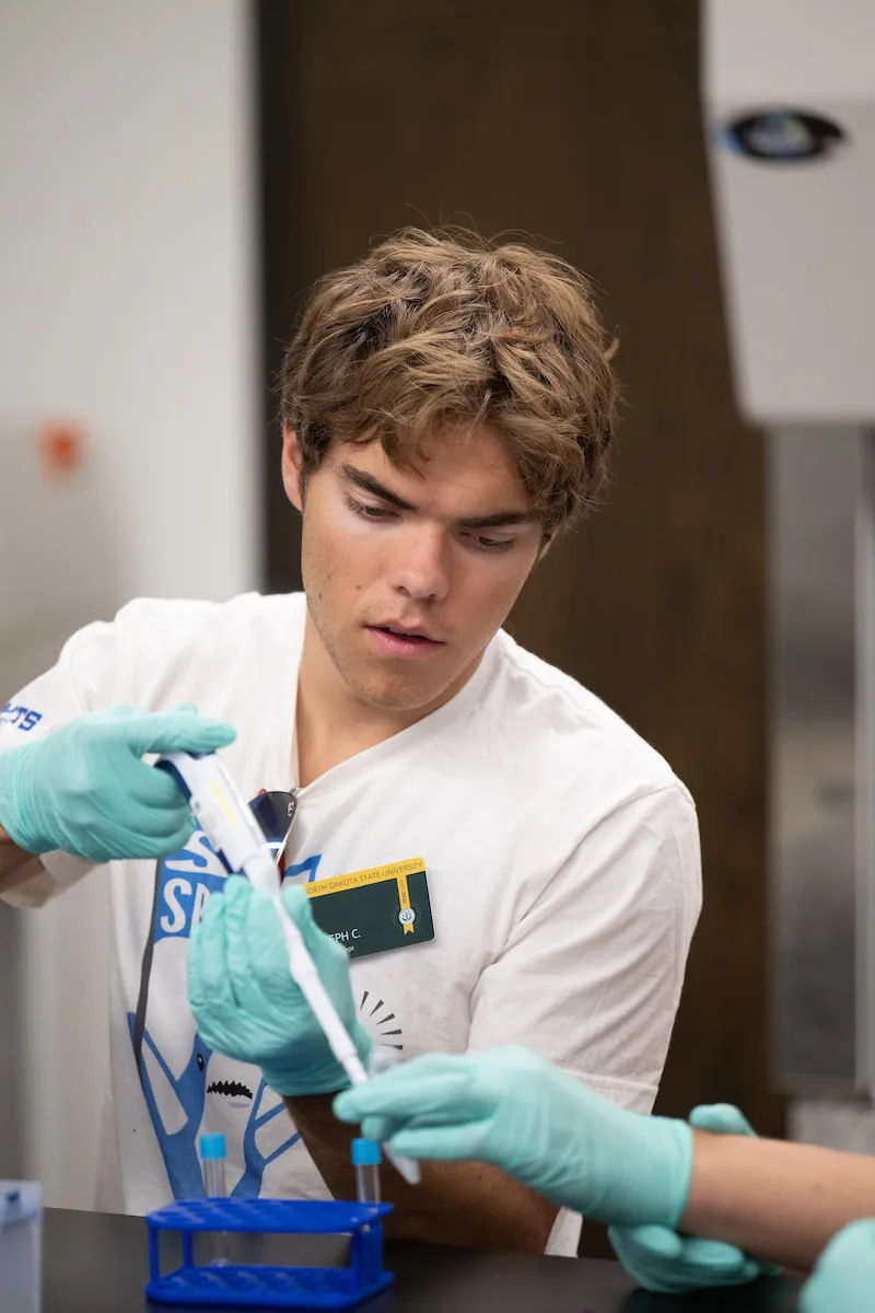 NDSU Honors College student Joseph Churchill uses a pipette.
