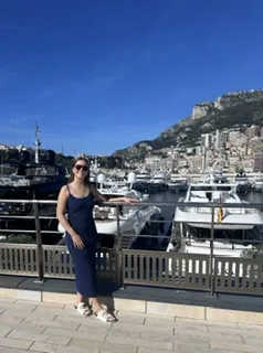 a student standing on a bridge in front of a port with many boats