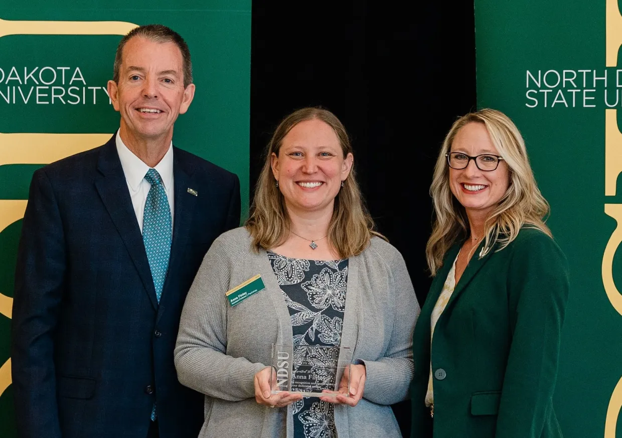 Dr. Finley stands between NDSU President Marshall and Provost Veil after receiving her award