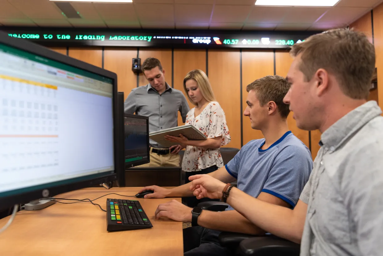 Students talking and working on a data project by a computer
