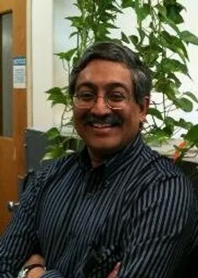 Dr. Shetty smiling confidently at camera.