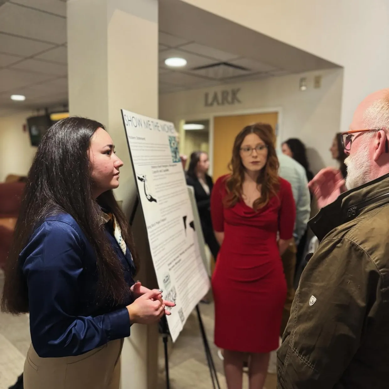Students discussing research poster. 