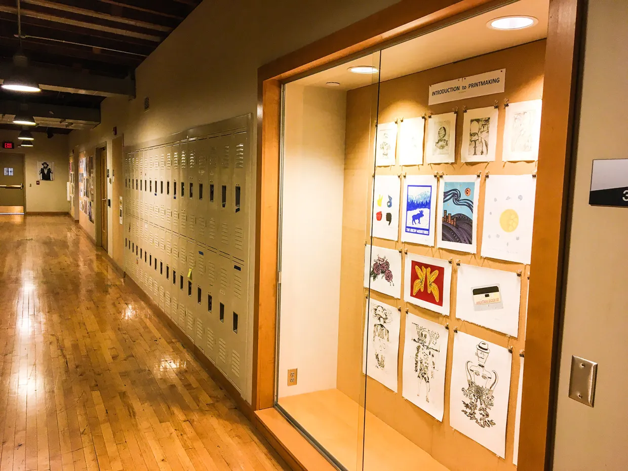 Hallway in Renaissance Hall with display case and lockers on the right side.