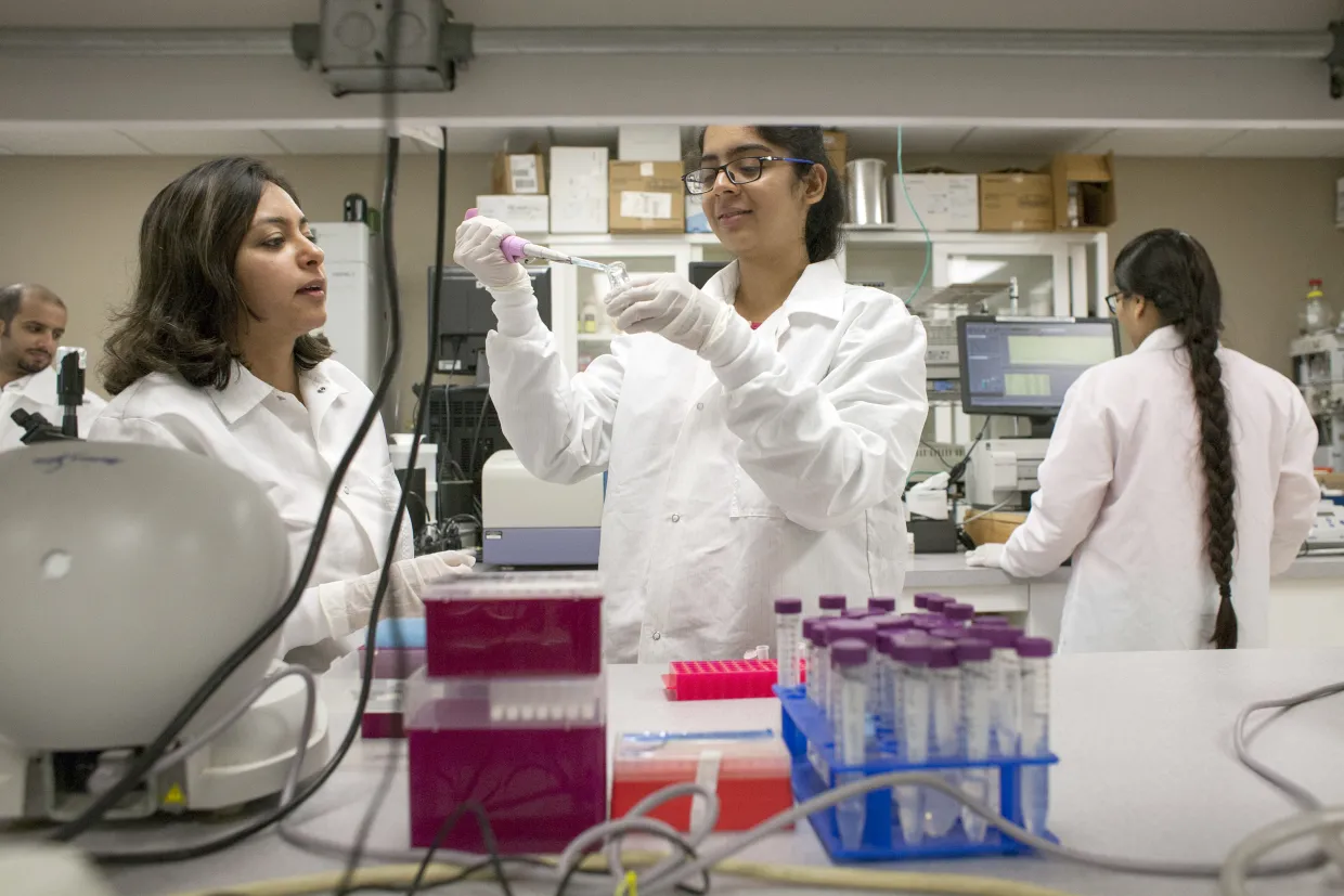 Students in a lab with one using a pipet