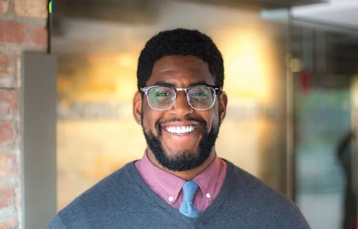 Kene Okigbo smiling confidently at camera.