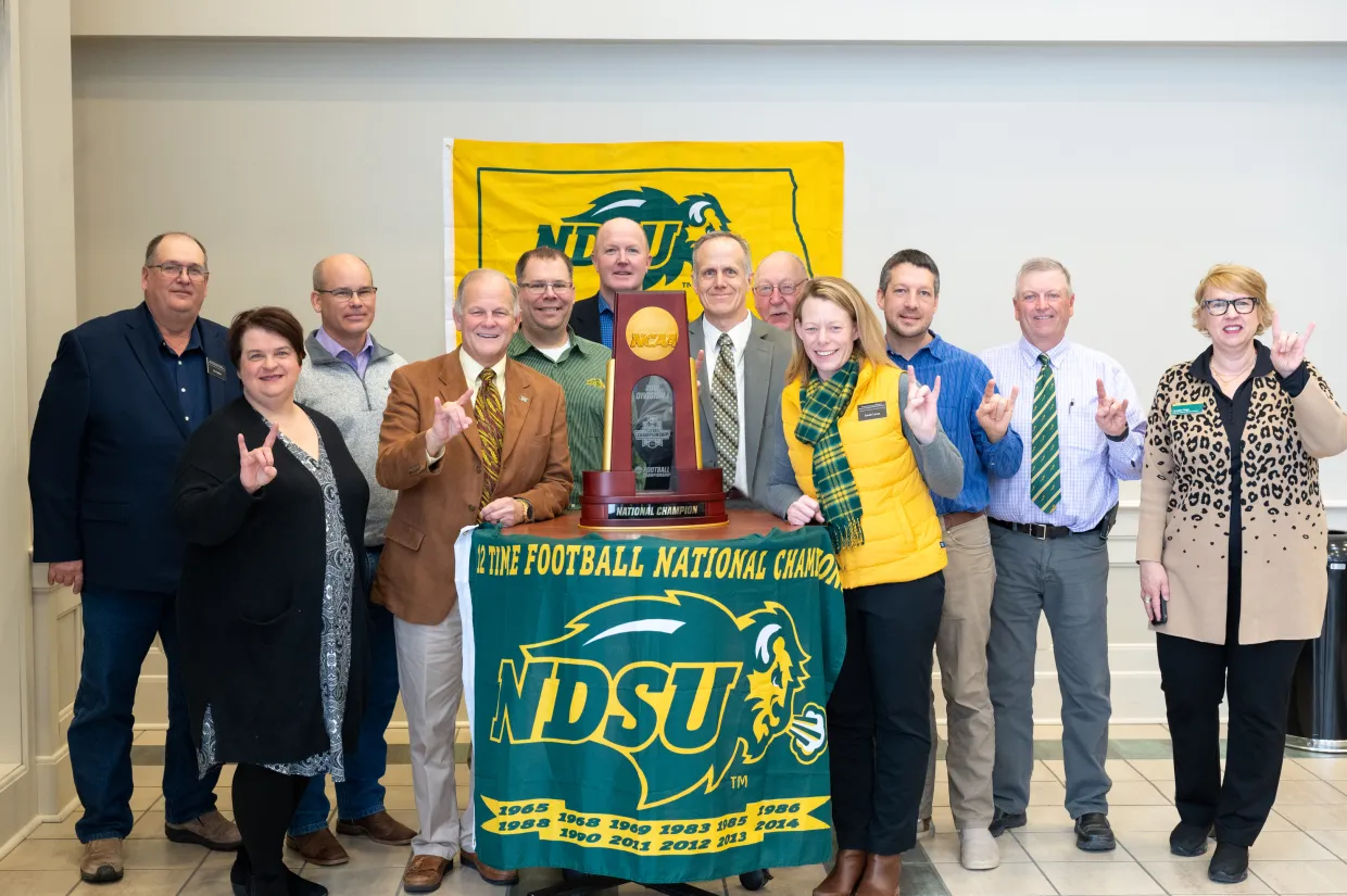 State Board of Agricultural Research and Extension group photo with NDSU football national championship trophy