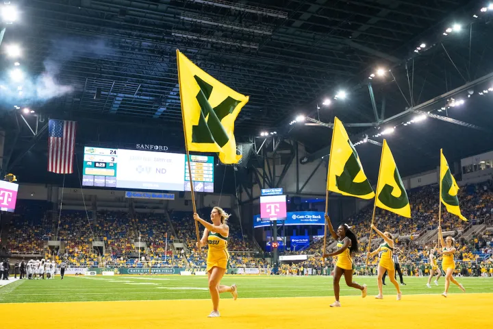 cheerleaders with NDSU flags on football field