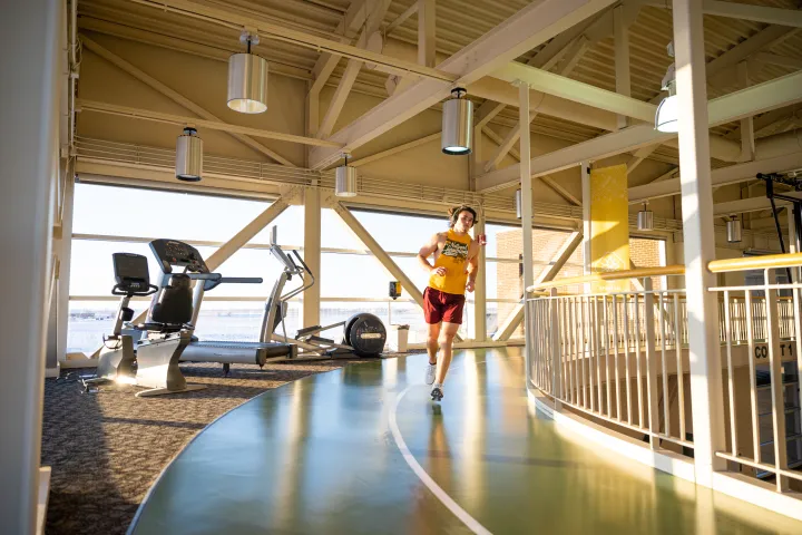 Male Student Running on Wellness Center 3rd Floor Track