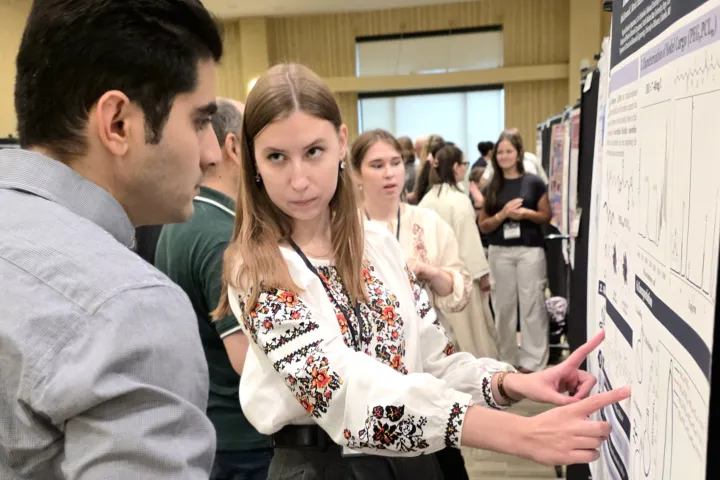 2026 summer REU students present their work at a poster session.