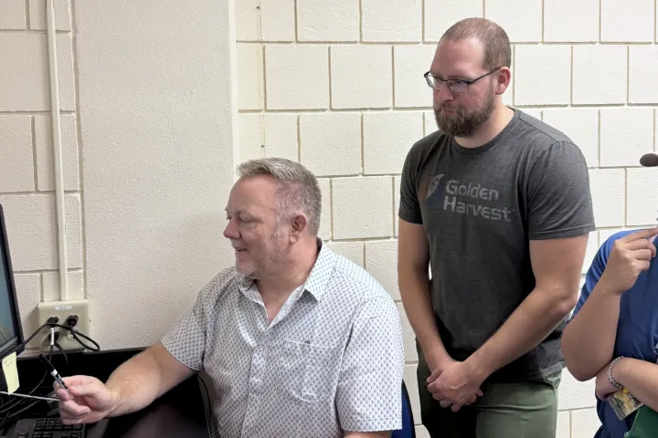 Ned Dochtermann and two of his students looking at a computer monitor.