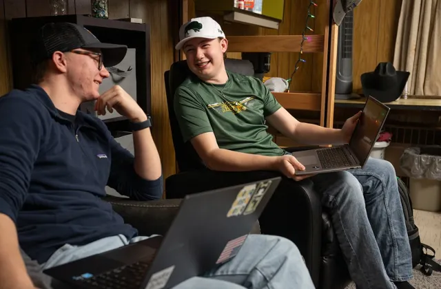 Tyler and Rylan talking and smiling in their shared dorm room
