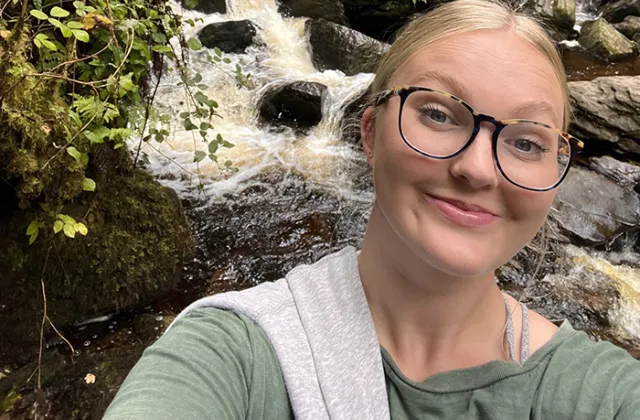Sophie Johnson standing in front of a waterfall in Ireland