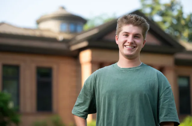 Austin Anderson smiles in front of Putnam Hall on NDSU Campus