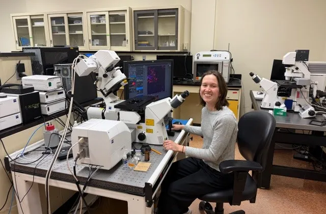 Student sitting at microscope.