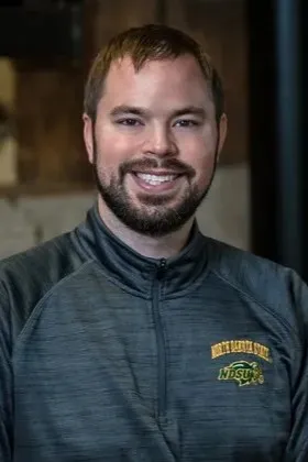 A smiling man wearing a North Dakota State University zip up jacket.