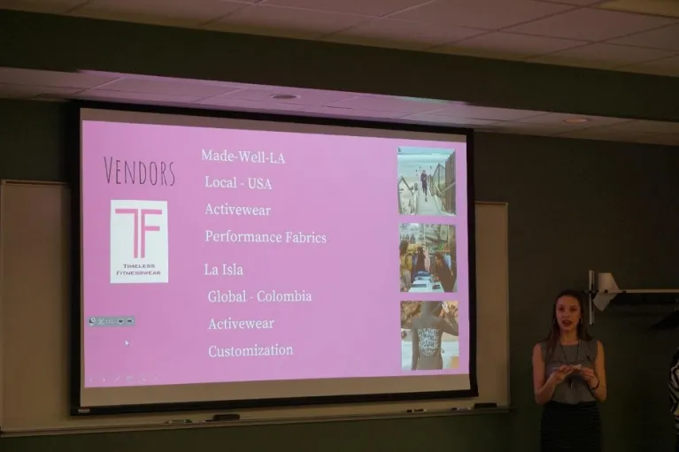 Student presenting in front of screen.