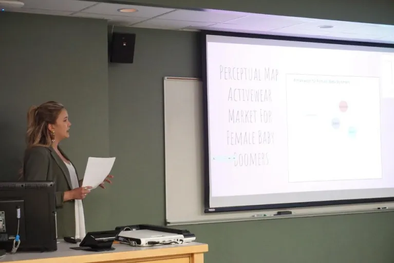 Student presenting while looking at screen.