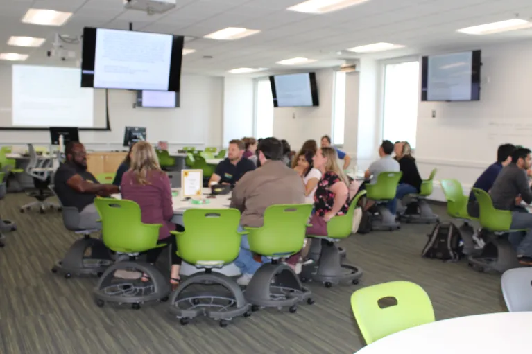 New faculty working at tables on case studies.
