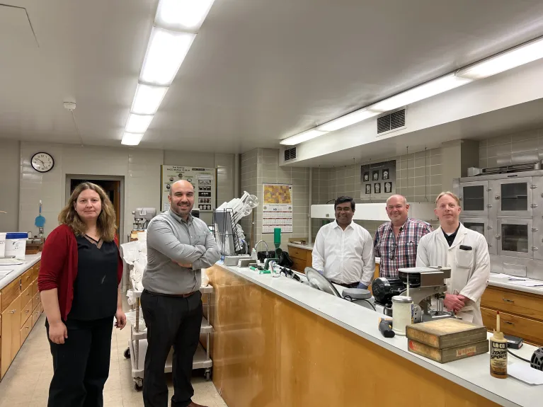 Staff and a small group on visit posing for a picture in bake lab