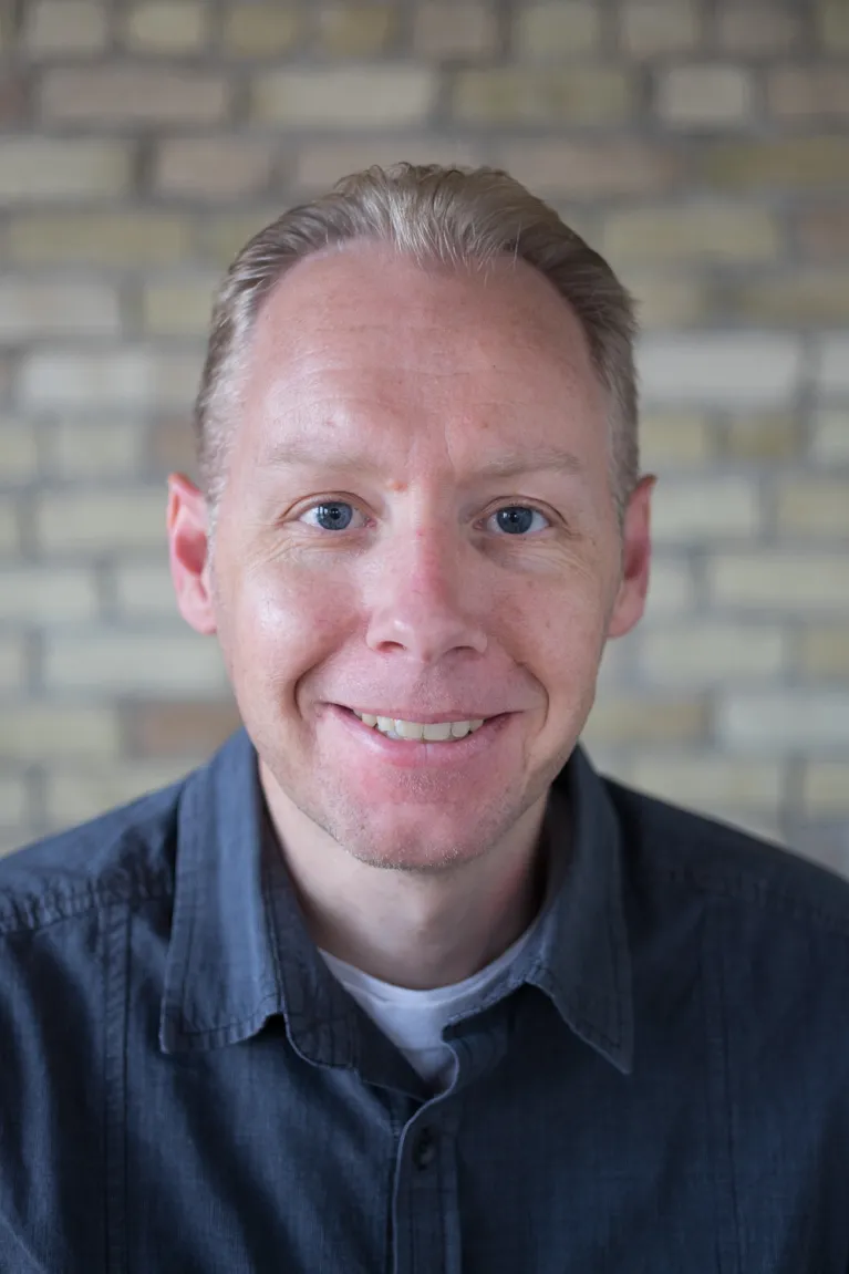 Jay Kost smiling confidently at the camera