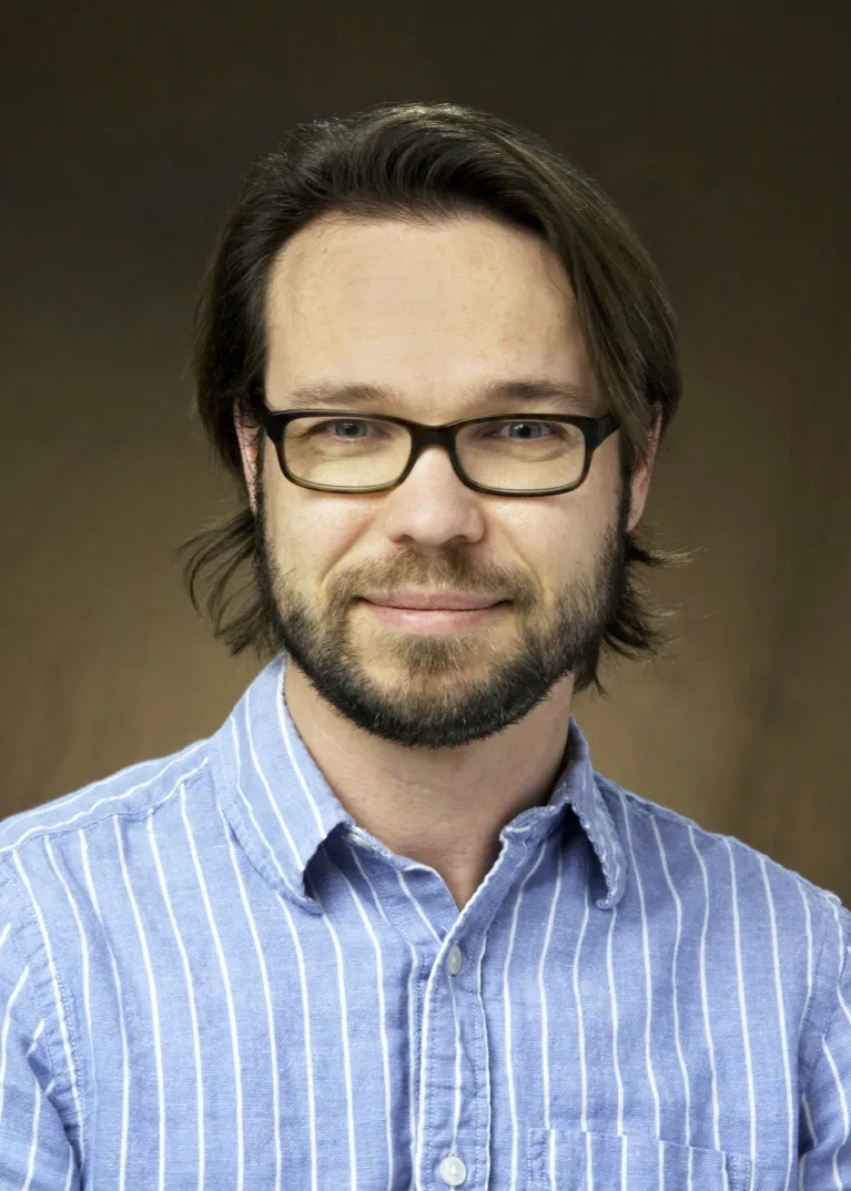 Creese smiling confidently at camera.