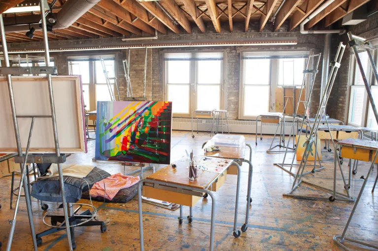 Bright colored art displayed in painting studio.