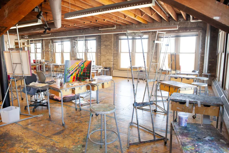 Chairs, tables and easels located in painting studio.