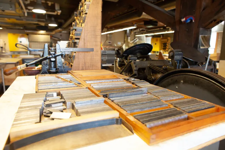 Printmaking supplies and equipment on tables in printmaking studio.