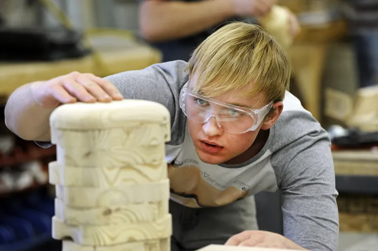 Student working with wood in woodshop.