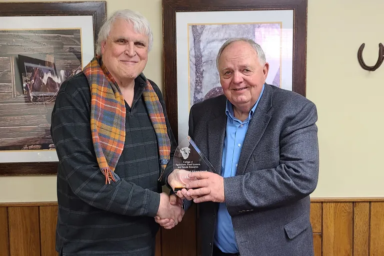 One man presents another man an award. 